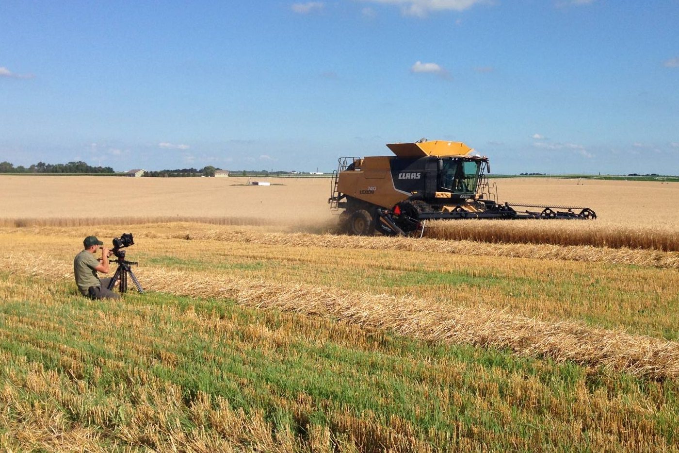 A Story Place Productions camera operator filming a combine harvesting a wheat field
